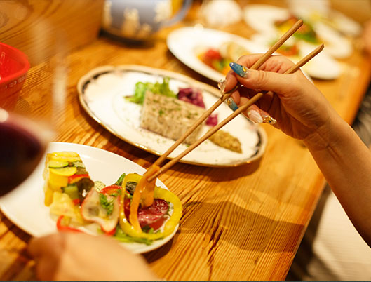 箸で料理を食べている